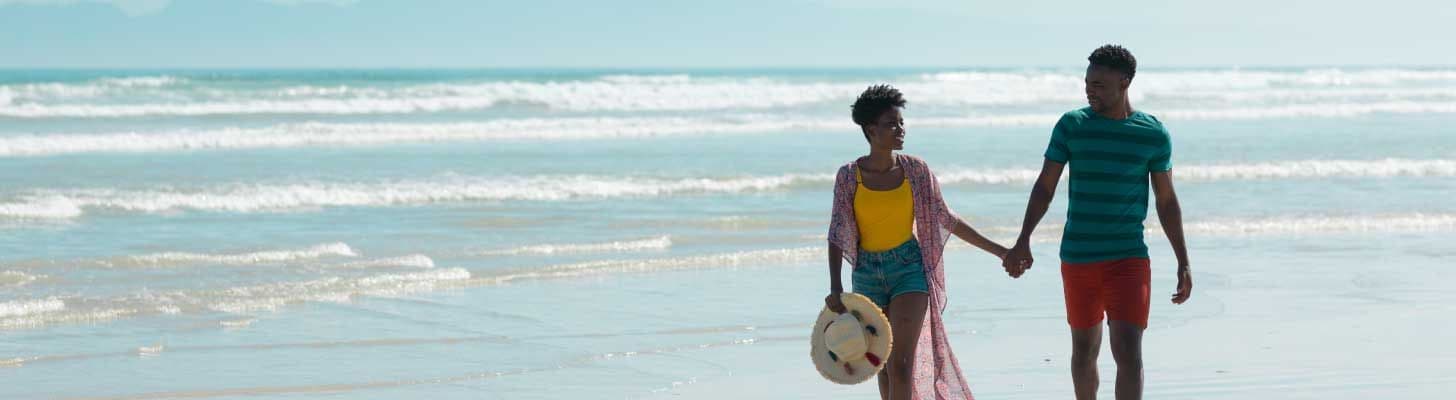 Couple walking hand-in-hand on a beach